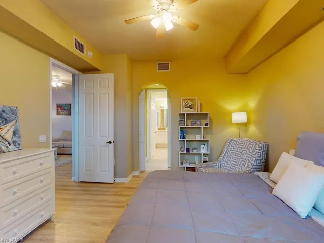 Bedroom featuring ceiling fan, light wood-type flooring, and ensuite bathroom