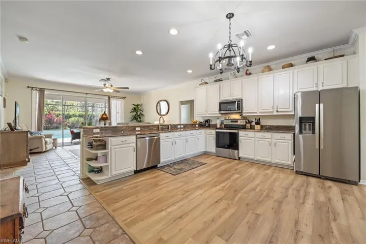 New wood laminate, Updated newer Stainless-Steel appliances, white cabinetry, and granite counters.