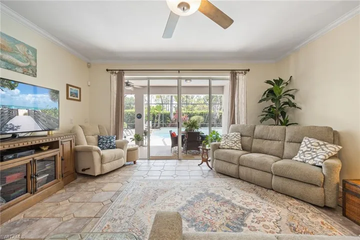 Spacious tiled living area leading out to pool area.