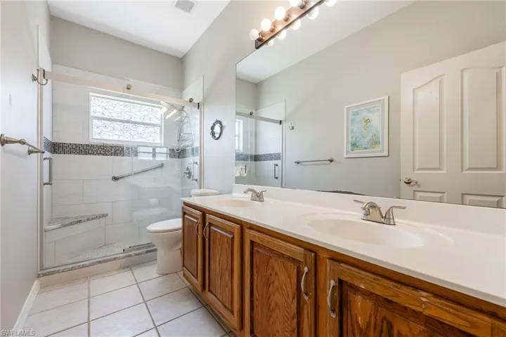 Guest bathroom with newer tile shower with stone bench.  Nice dual sink vanity with plenty of counter space.