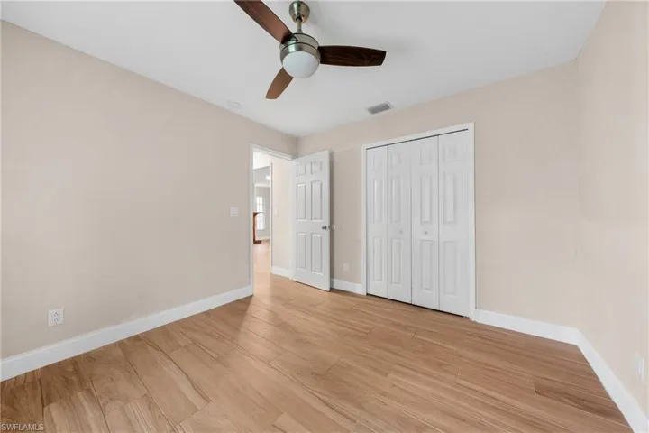 Interior room featuring wood-finish flooring, light neutral wall paint, and white baseboards