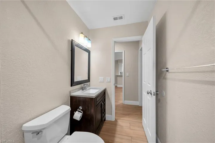 Bathroom featuring a dark wood-finish vanity with a light-toned countertop, rectangular sink, and chrome faucet