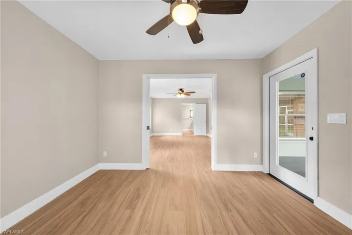 Open-concept interior featuring wood-finish flooring, neutral wall tones, and white trim