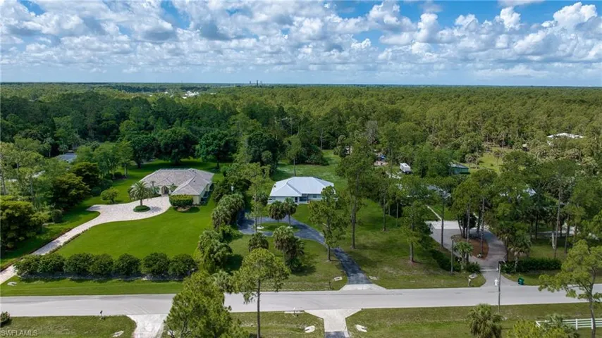 Aerial perspective showcasing two properties with extensive green landscaping
