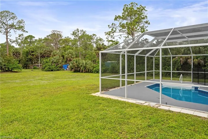 Screened-in swimming pool featuring a cool deck surround and integrated pool steps