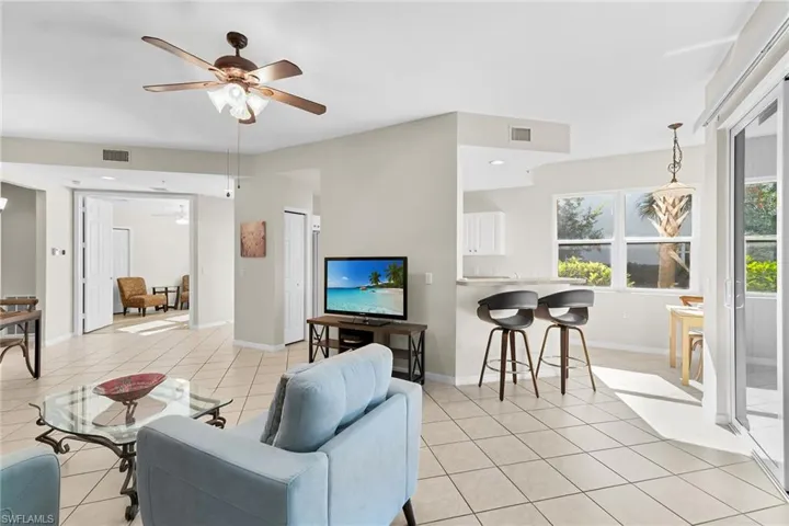 Living room with ceiling fan and light tile patterned floors