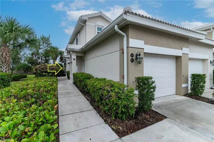 View of property exterior featuring an attached garage, stucco siding, and driveway