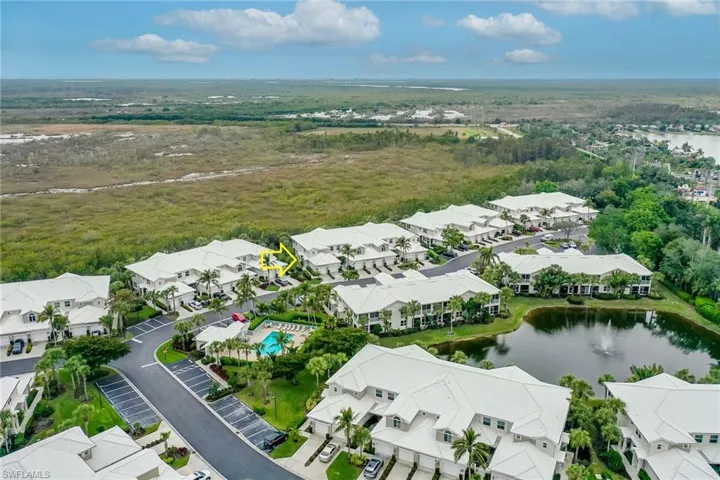 Aerial view of residential area featuring a large body of water and a forest