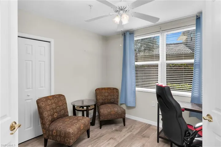 Office space with light wood-style floors and a ceiling fan