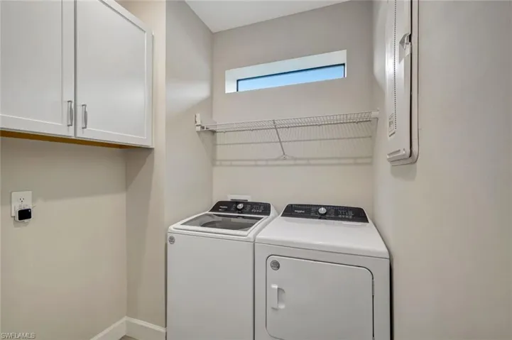 Washroom featuring cabinet space and separate washer and dryer