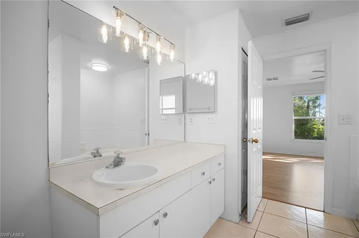 Bathroom with light tile patterned flooring and vanity
