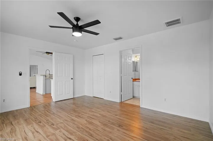 Unfurnished bedroom with light wood-style flooring, ceiling fan, and a closet