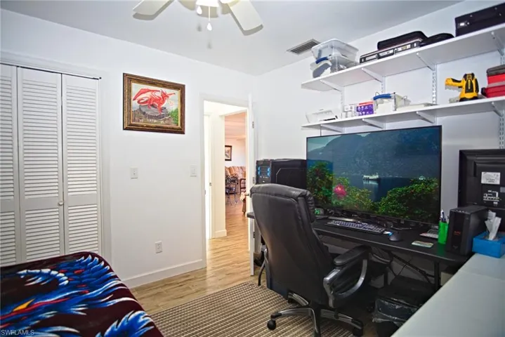 Office/  guest bedroom featuring light wood finished floors and ceiling fan