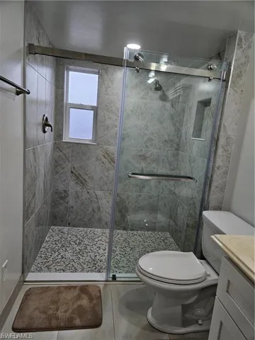 Bathroom featuring vanity, a shower stall, and tile patterned flooring