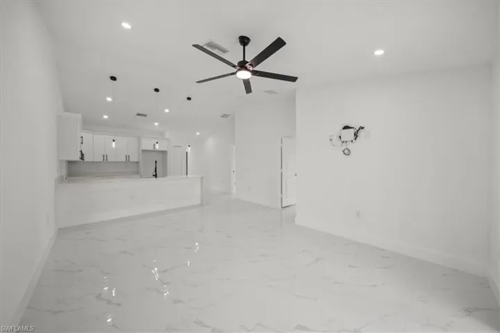 Unfurnished living room featuring light marble finish floors, recessed lighting, and a ceiling fan