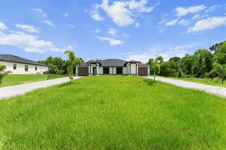 Prairie-style home with concrete driveway and a front lawn