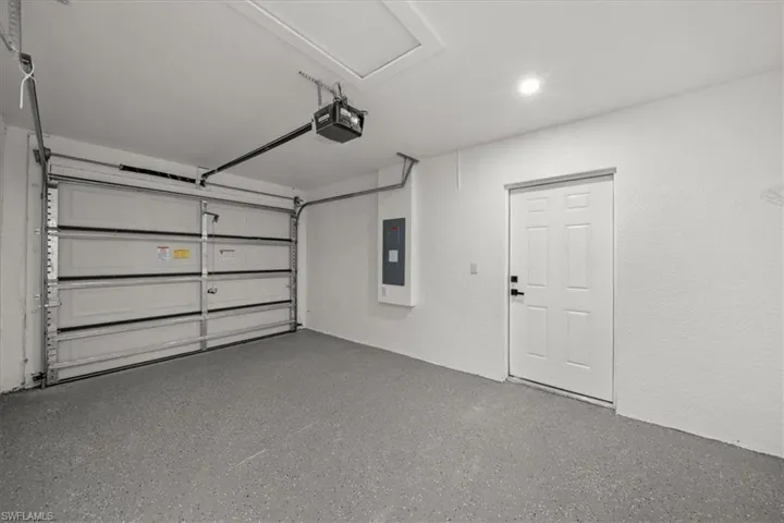Garage featuring electric panel and a garage door opener