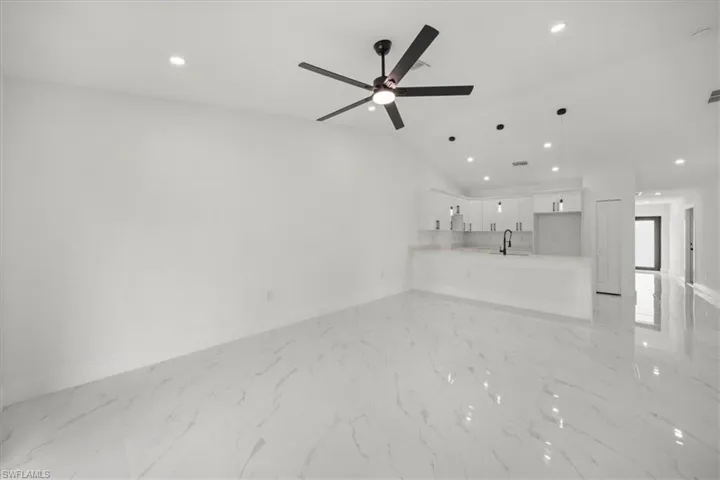 Unfurnished living room featuring recessed lighting, a ceiling fan, and light marble finish flooring