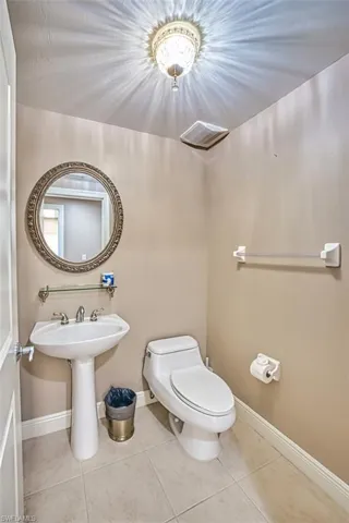 Bathroom featuring tile patterned floors, sink, and toilet