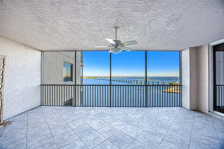 Unfurnished sunroom featuring a water view and ceiling fan