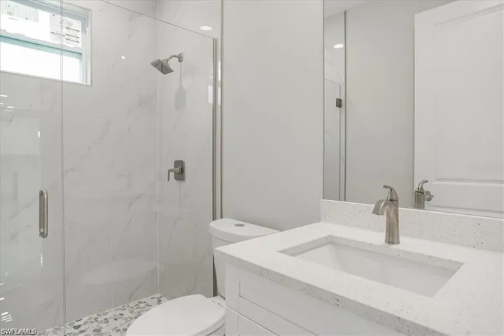 Bathroom with vanity, toilet, and walk in shower