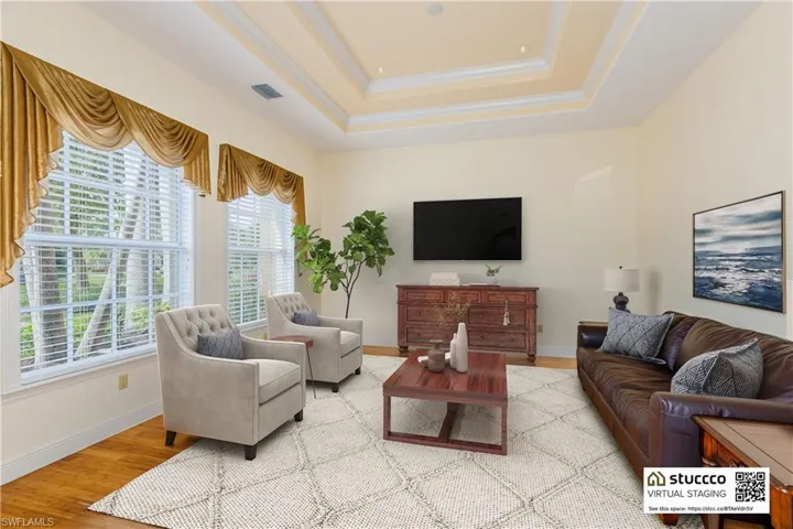Living room featuring wood-type flooring and a tray ceiling