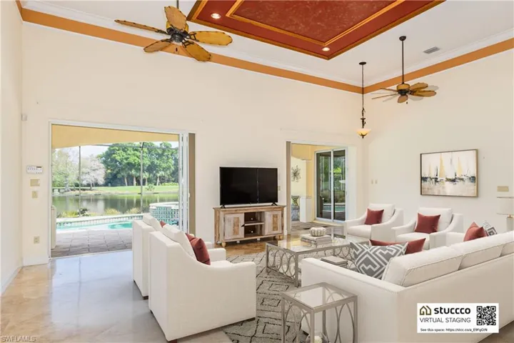 Living room with tile flooring, a high ceiling, ceiling fan, and a water view