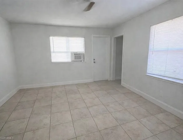 Efficiency Bedroom/Living Room light tile patterned flooring, ceiling fan, and cooling unit