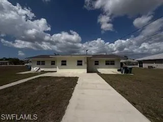 Rear view of property featuring a yard and a patio