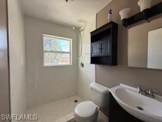 1BR Full bath with vanity, a stall shower, and a textured ceiling