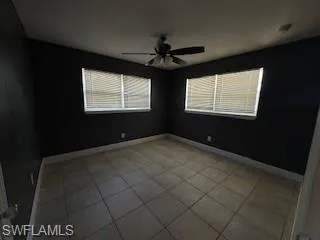 1 BR Spare room featuring light tile patterned floors and a ceiling fan