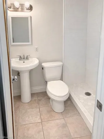 Efficiiency Full bath with a stall shower and light tile patterned floors