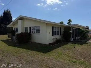 View of side of home featuring a yard