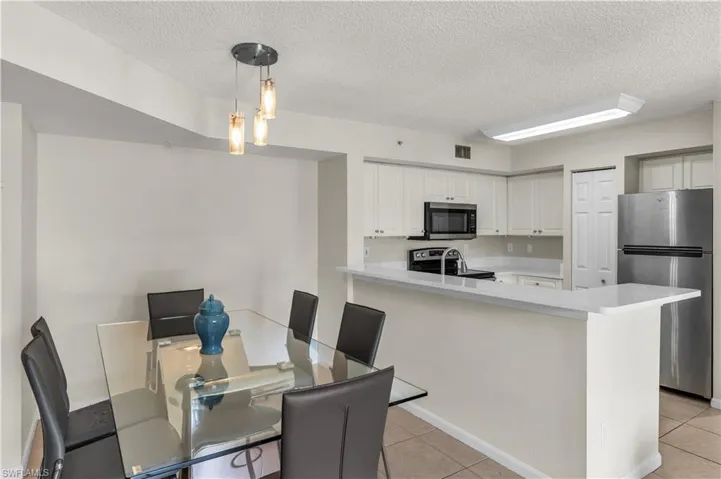 Dining room featuring light tile patterned floors and a textured ceiling