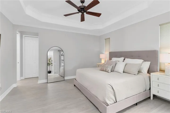 Bedroom with ceiling fan, light wood finished floors, and crown molding