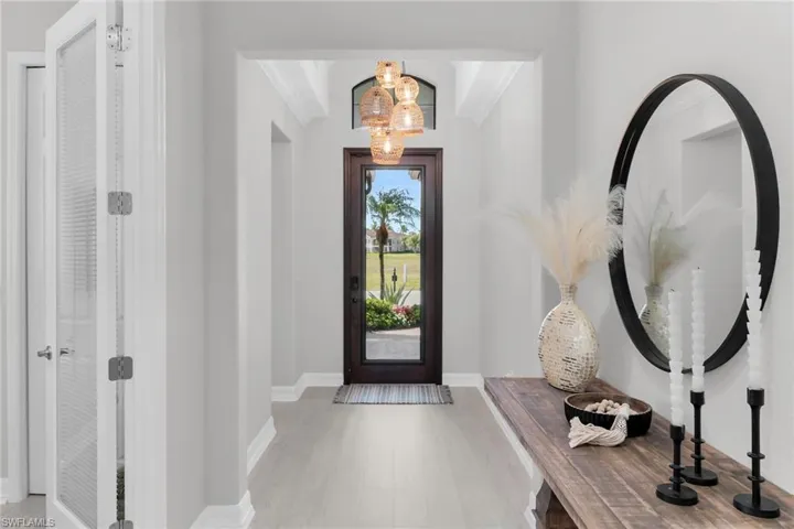 Entrance foyer with a chandelier and light wood-style flooring