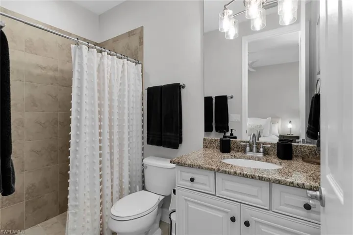 Full bathroom with vanity, ensuite bathroom, and a tile shower