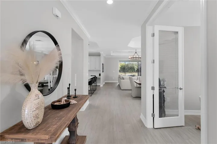 Corridor with crown molding and light wood-type flooring