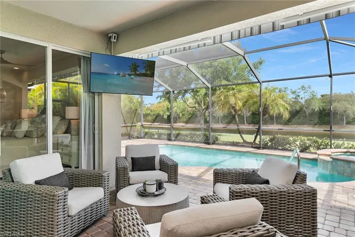 Integrated pool / hot tub with a sunroom, a lanai, and a patio