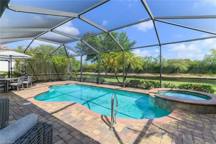 Integrated pool / spa with a sunroom, outdoor dining area, a lanai, and a patio area