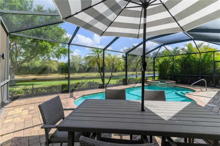 Integrated pool / spa with a patio area, a sunroom, a lanai, and a water view
