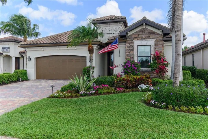 Mediterranean / spanish-style house featuring a garage, stone siding, decorative driveway, stucco siding, and a front lawn