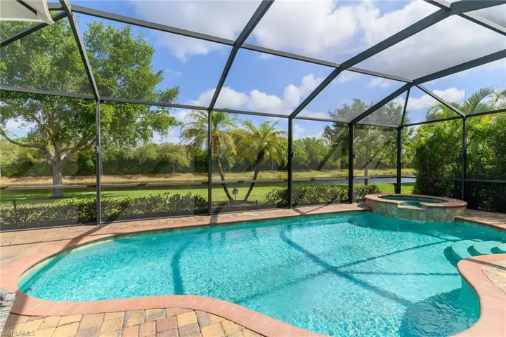 Combined pool / hot tub featuring a sunroom, a lanai, and a water view