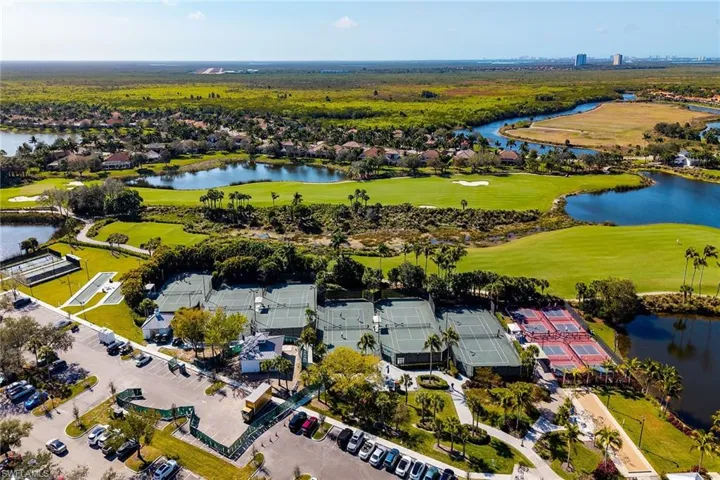 Aerial perspective of suburban area with a golf club and a large body of water