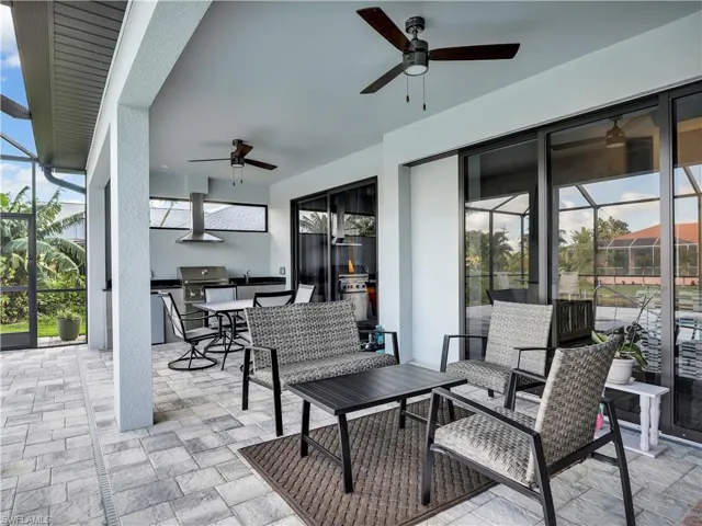 View of patio / terrace featuring area for grilling, glass enclosure, and ceiling fan