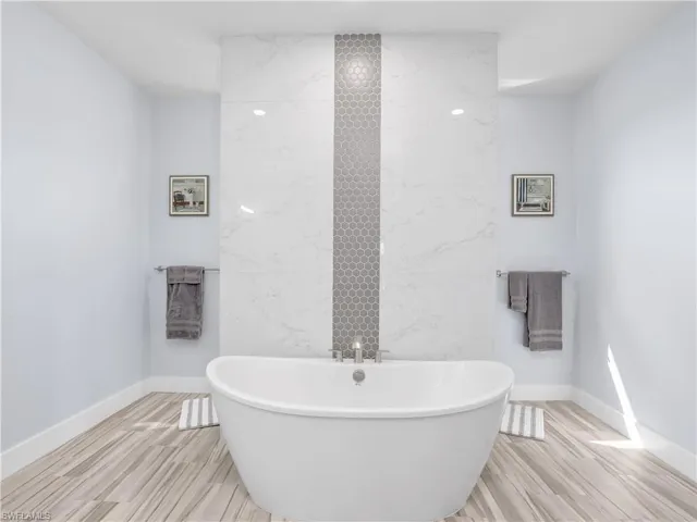Bathroom featuring wood-type flooring and a tub