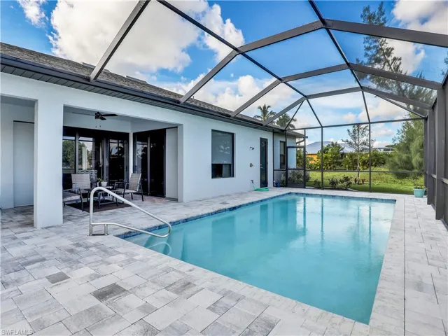 View of pool with ceiling fan, a lanai, and a patio