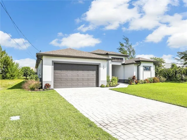 View of front of property featuring a front lawn and a garage