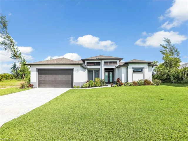 Prairie-style home with a garage and a front lawn