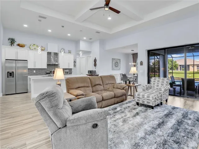 Living room featuring light hardwood / wood-style floors, beam ceiling, and ceiling fan